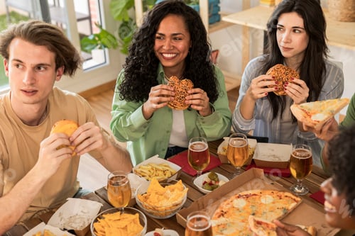 Preview: multiracial friends eating burgers at home, millennials meeting in apartment