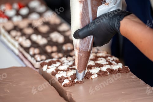 Preview: Baker decorating chocolate cake. Background with selective focus and copy space.
