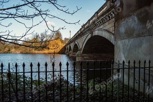 Preview: Mesmerizing view of the bridge with stone arches over the river behind the metal fence