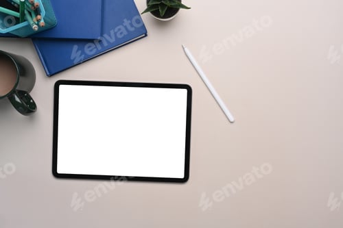 Preview: Top view of mock up digital tablet with blank screen, stylus pen, coffee cup and notebook.