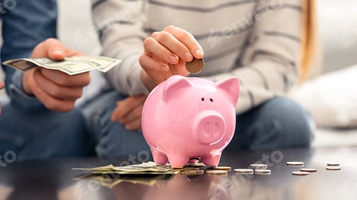 Preview: Sad family putting money into piggybank at home, close up