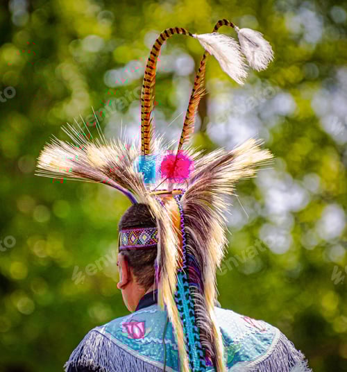 Preview: Closeup shot of the head of a person in a traditional Native Indian-American hat with feathers