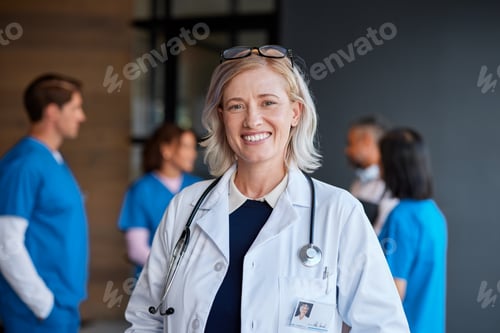 Preview: Smiling mature female physician in hospital
