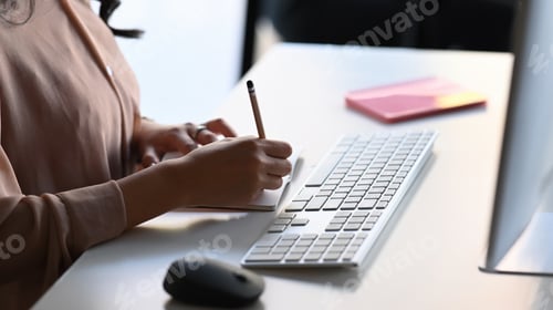 Preview: Close up view of businesswoman working in office with computer and writing business plan.