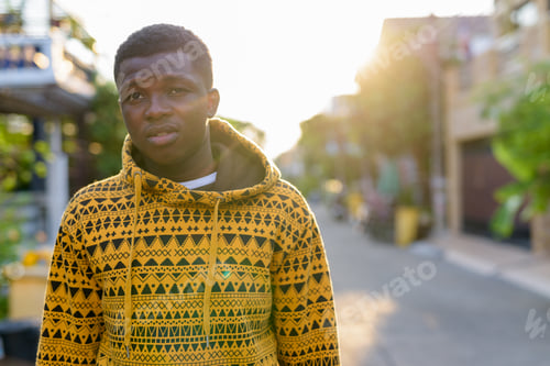Preview: Young black African man thinking while looking at distance and w