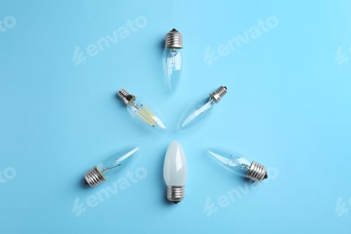 Preview: Different lamp bulbs on light blue background, flat lay