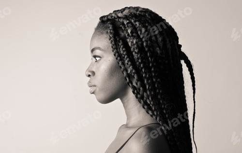 Preview: Side profile of a young African American woman with long braided hair