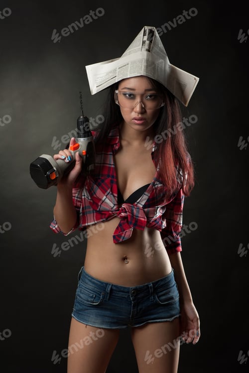 Preview: Young Asian High Fashion Glamour Model In Sexy Shorts, Safe Glasses And Newspaper Hat Holding