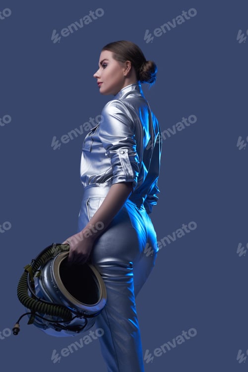 Preview: Back view of female astronaut holding helmet
