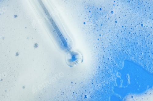 Preview: White foam on a blue background. A pipette that collects white foam. Cleansing cosmetics.
