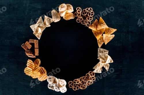 Preview: top view of round frame made from various unhealthy snacks on black