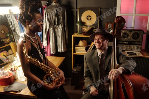 Preview: Young Black Woman Holding Saxophone and Middle Aged Caucasian Man Playing Bass