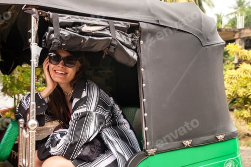 Preview: Woman tourist with sunglasses in casual clothing sitting in tuk tuk public transport in Sri Lanka