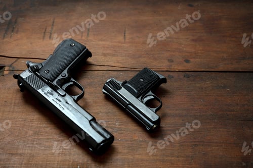 Preview: Pistols guns on wooden table. Auto metal weapons side view