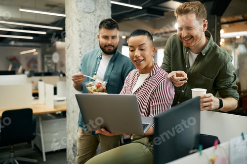 Preview: Happy start-up team having fun while surfing the net on a break in the office.