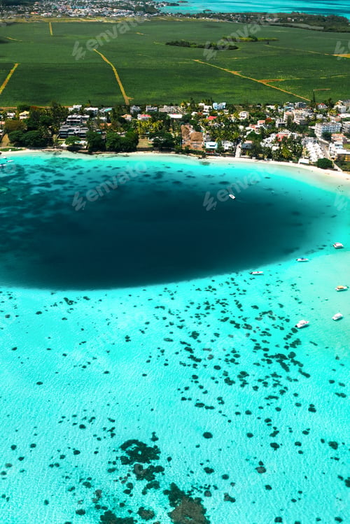 Preview: Top view of the Blue Bay lagoon of Mauritius. A boat floats on a turquoise lagoon