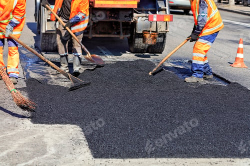 Preview: Closeup shot of road workers repairing part of the road with fresh hot asphalt