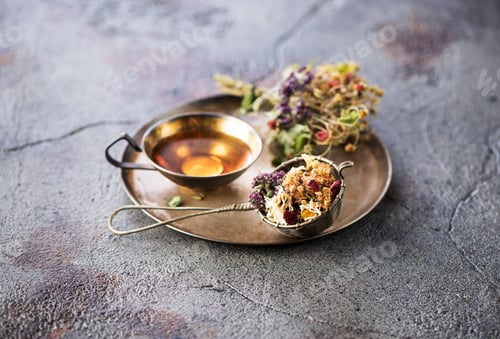 Preview: Herbal tea in a metal cup, a vintage strainer and dry medicinal herbs