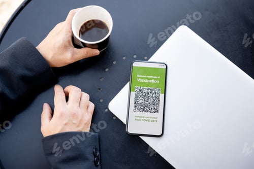 Vista previa: Hombre sostiene el teléfono con la Aplicación de Vacunación contra el Coronavirus