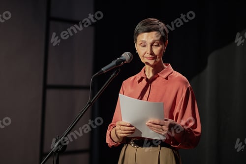 Preview: Middle Aged Caucasian Woman Reading Script on Stage during Talent Competition