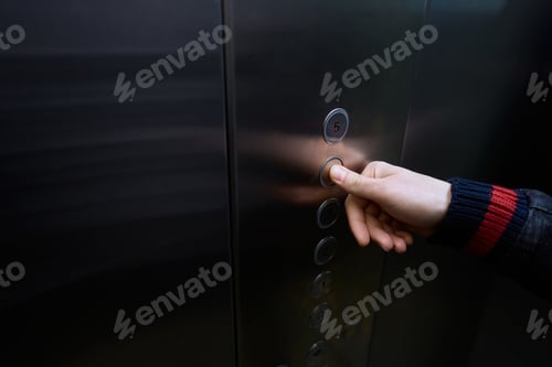 Preview: Male in the passenger elevator cabin presses floor selection button