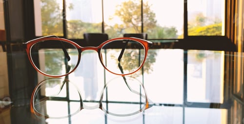 Preview: Eyeglasses on a Glass Table Reflecting Window