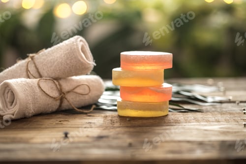Preview: Spa handmade soap and a towel, the composition of the tropical leaves wooden background