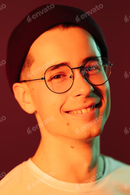 Preview: Close up portrait of smiling handsome guy in white t-shirt over pink background