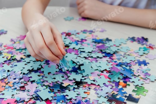 Preview: Caucasian girl collects puzzles on the table.