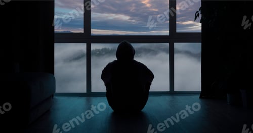 Preview: Lonely person from behind sitting near the window and looking at clouded landscape