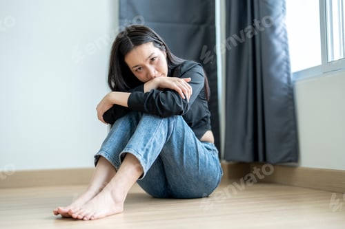 Preview: Young woman feeling sad and depressed on the floor at home