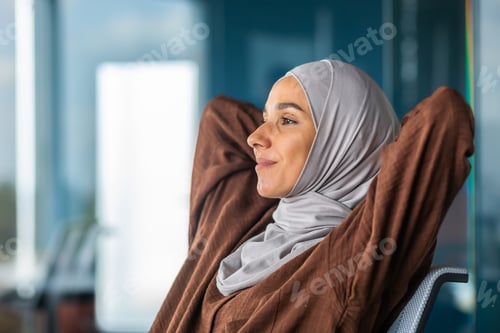Preview: Successful completion of the project, working day. A young Arab woman in a hijab is resting at the