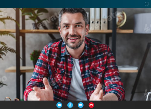 Preview: Adult man with gray hair looks at the camera speaks with his partner online sitting at table