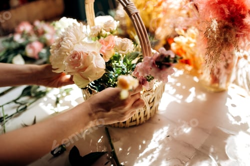 Preview: Florist collections a bouquet in the basket from fresh peonies and roses in the flower shop