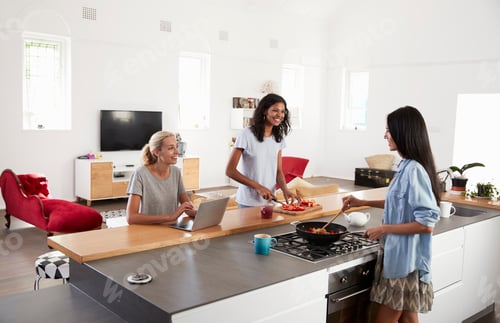 Preview: Three Female Friends Preparing Meal Together In Modern Kitchen