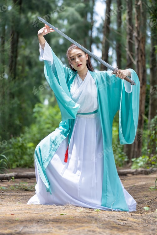 Preview: Young beautiful Asian woman dressed in ancient Chinese warrior style with ancient fan