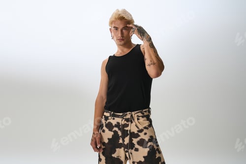 Preview: Stylish young man showcases modern fashion with a confident pose in a studio setting