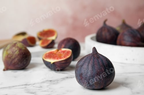 Preview: Tasty ripe fig fruits on marble table against pink background. Space for text