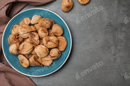Preview: Plate of dried figs on grey background, top view with space for text. Healthy fruit