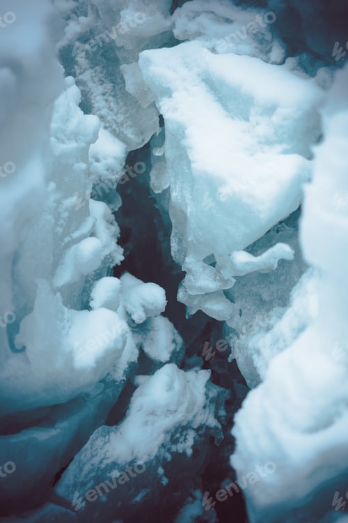 Preview: Vertical closeup shot of an ice crevasse in the snowy covered ground