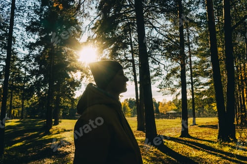 Preview: Young man in autumn forest. Profile view.
