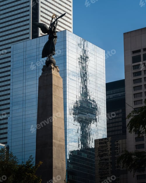 Preview: Reflection of the CN Tower in a glass building with a monument in the foreground in Toronto