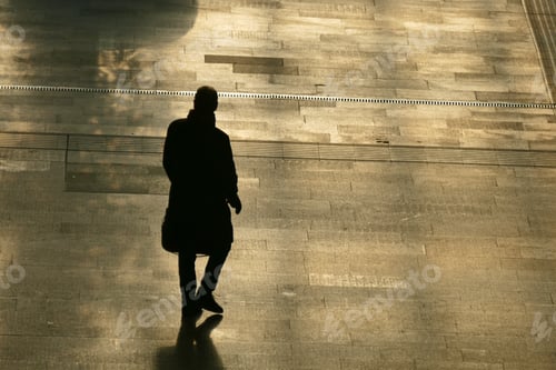 Preview: Silhouette of the lonely man walking on the street.