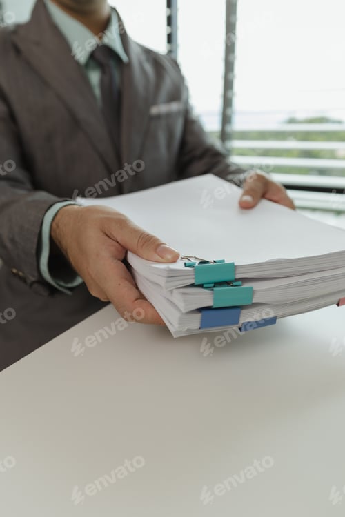 Preview: An office worker is putting important documents together to keep everything safe. A businessman is p