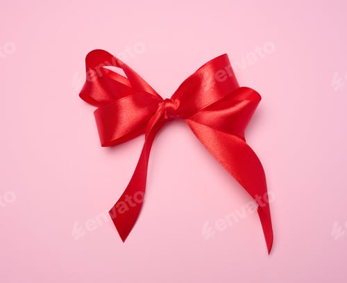 Preview: Red silk bow on pink background, top view