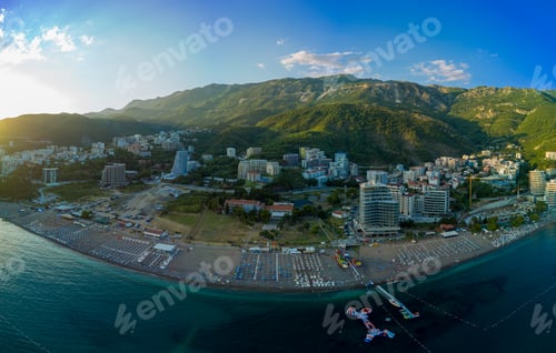 Preview: Panorama of beach with sun umbrellas, sunbeds and people relaxing in the town of Becici