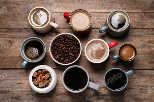 Preview: Cups of hot coffee with beans and sugar on wooden table, flat lay