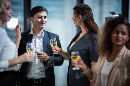 Preview: A group of business people holding a glass of champagne in a party to celebrate their success