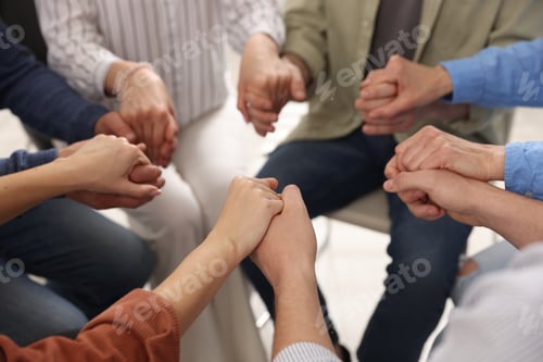 Preview: People holding hands during group psychotherapy session indoors, closeup
