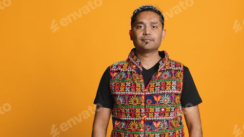 Preview: Happy man in traditional attire smiling, studio background